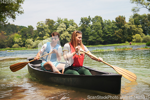 Image of couple of explorers conoining on wild river