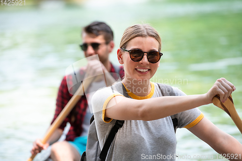 Image of couple of explorers conoining on wild river