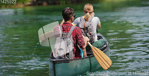 Image of couple of explorers conoining on wild river