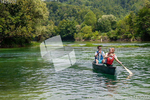 Image of couple of explorers conoining on wild river