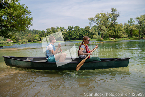 Image of couple of explorers conoining on wild river