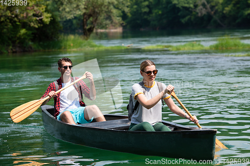 Image of couple of explorers conoining on wild river