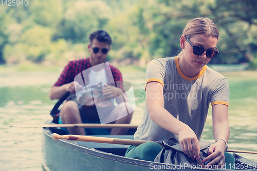 Image of couple of explorers conoining on wild river