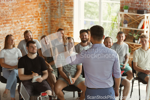 Image of Male speaker giving presentation in hall at university workshop