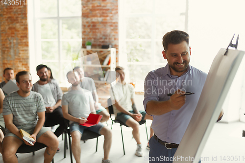 Image of Male speaker giving presentation in hall at university workshop