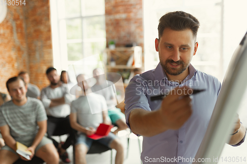 Image of Male speaker giving presentation in hall at university workshop