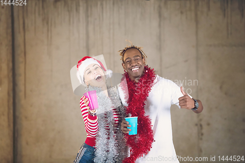 Image of young multiethnic business couple celebrating new year party