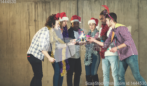 Image of multiethnic group of casual business people lighting a sparkler