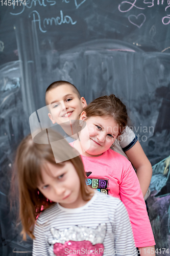 Image of group of kids standing in front of chalkboard