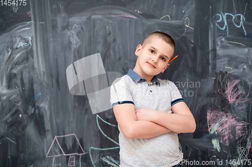 Image of portrait of little boy in front of chalkboard