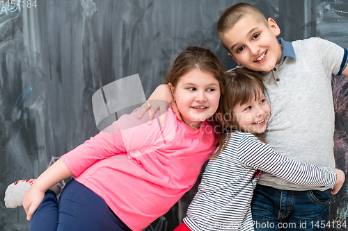 Image of group of kids hugging in front of chalkboard