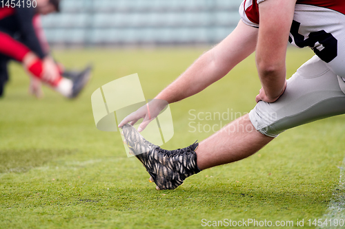Image of american football players stretching and warming up