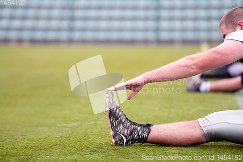 Image of american football players stretching and warming up