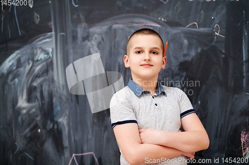 Image of portrait of little boy in front of chalkboard