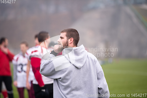 Image of american football players stretching and warming up