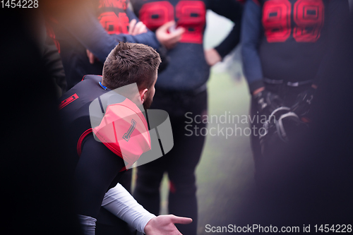 Image of american football player discussing strategy with his team