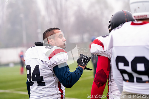 Image of confident American football players leaving the field