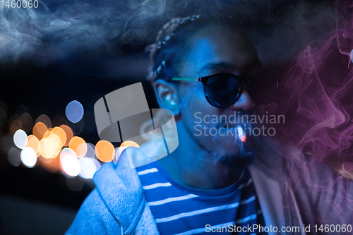 Image of african american man smiking cigarette  at nigth