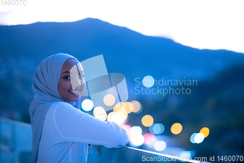 Image of African  modern Muslim woman in night at balcony