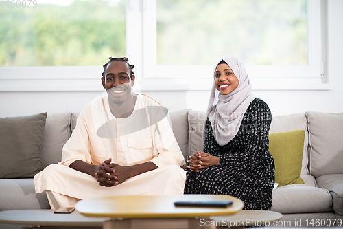 Image of african couple at home reading quaran