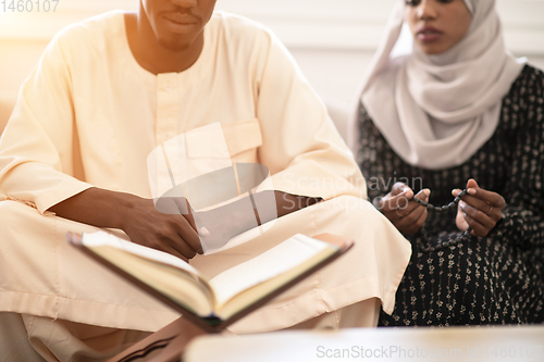Image of african couple at home reading quaran