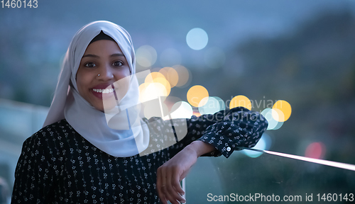 Image of African  modern Muslim woman in night at balcony