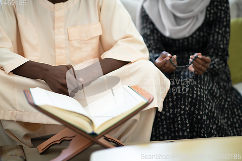 Image of african couple at home reading quaran
