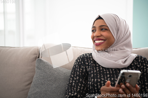 Image of african  woman using smartphone at home