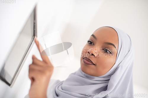 Image of african woman using smart home screen