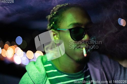 Image of african american man smiking cigarette  at nigth