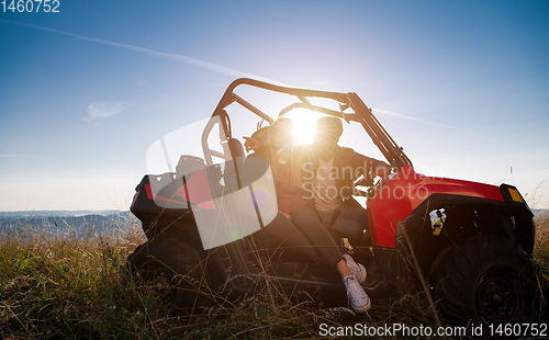 Image of young couple driving a off road buggy car