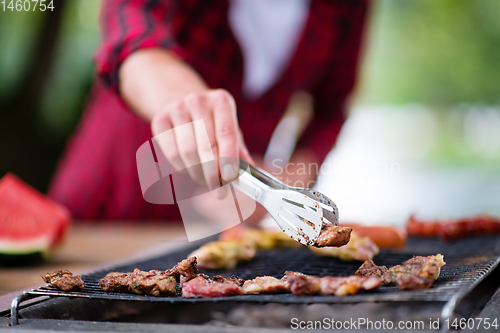 Image of Man cooking tasty food on barbecue grill