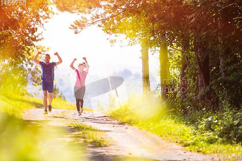 Image of young couple jogging on sunny day at nature