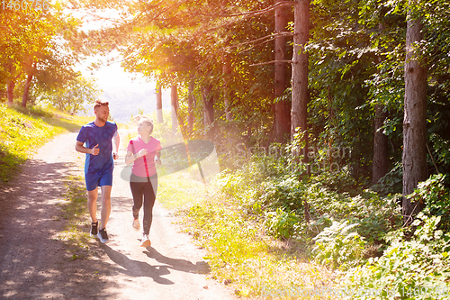 Image of young couple jogging on sunny day at nature