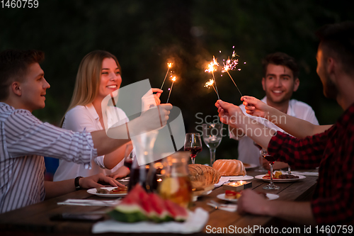 Image of happy friends having french dinner party outdoor