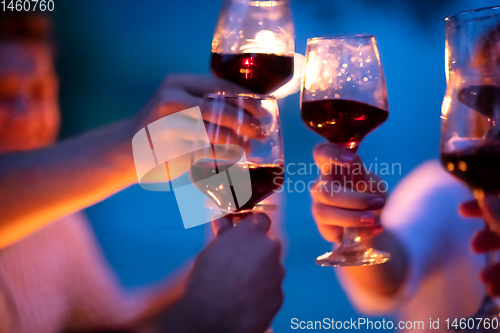 Image of friends toasting red wine glass during french dinner party outdo