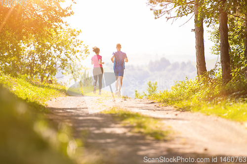 Image of young couple jogging on sunny day at nature