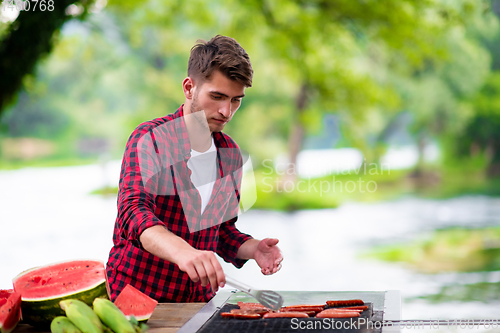 Image of Man cooking tasty food on barbecue grill