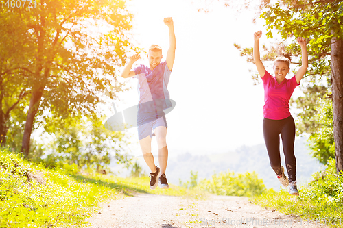 Image of young couple jogging on sunny day at nature