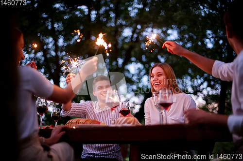 Image of happy friends having french dinner party outdoor