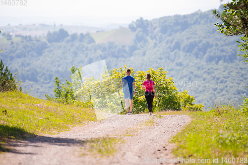 Image of young couple jogging on sunny day at nature