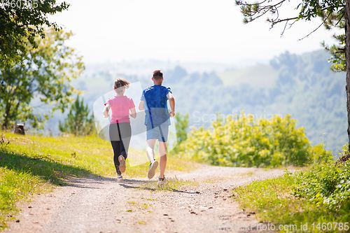 Image of young couple jogging on sunny day at nature