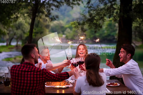 Image of happy friends having french dinner party outdoor