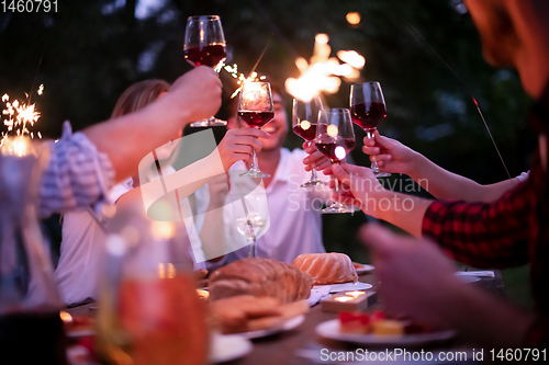 Image of happy friends having french dinner party outdoor