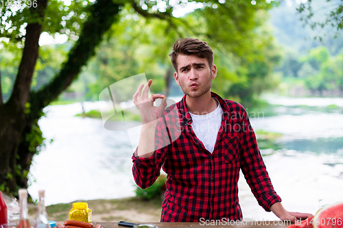 Image of Man putting spices on raw meat  for barbecue grill