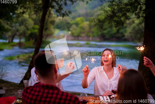 Image of happy friends having french dinner party outdoor