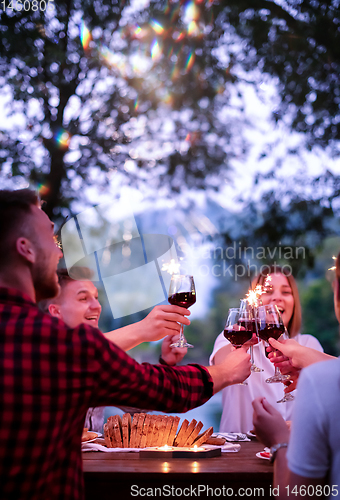 Image of happy friends having french dinner party outdoor