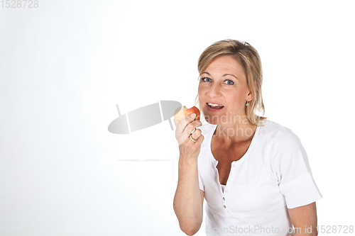 Image of Blond cute woman eating an apple