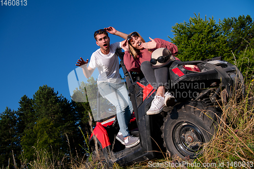 Image of young couple driving a off road buggy car