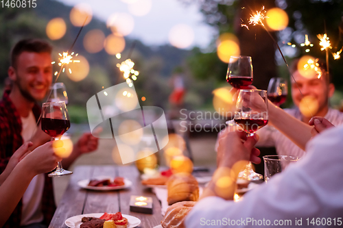 Image of happy friends having french dinner party outdoor